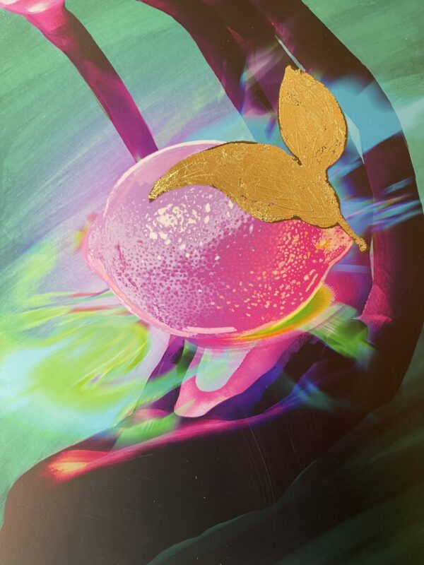 Colourful lemon with golden leaf between hands